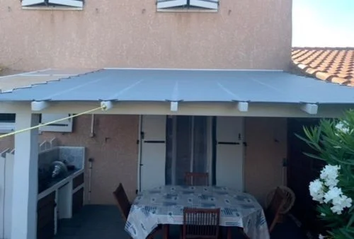 Toile de pergola sur-mesure gris galet pour abri terrasse bois, fixation par œillets et sandow